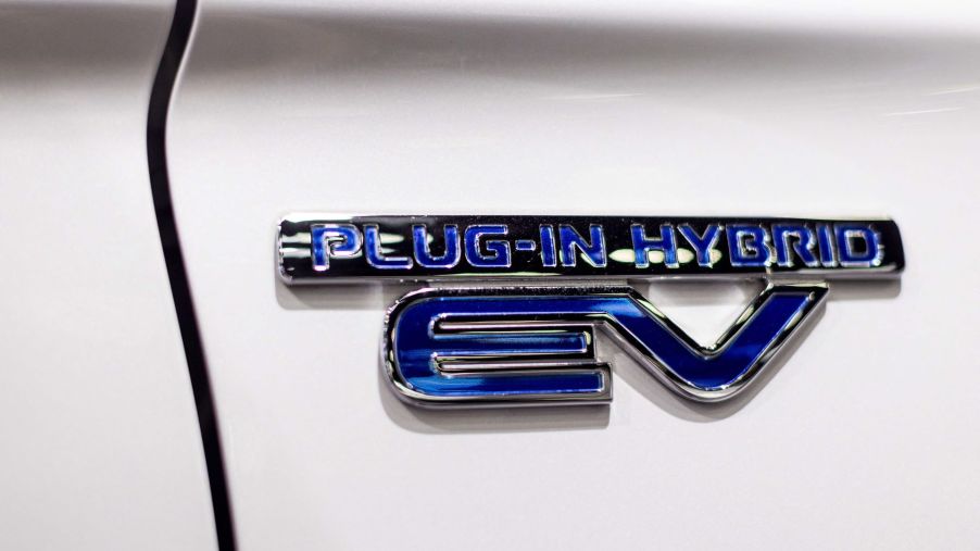A plug-in hybrid EV badge on a Mitsubishi Outlander PHEV SUV