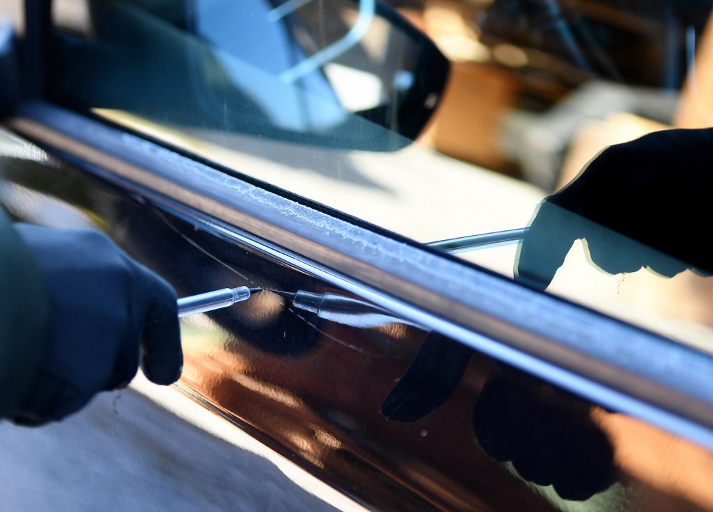 someone scratching a car's paint with a screw driver