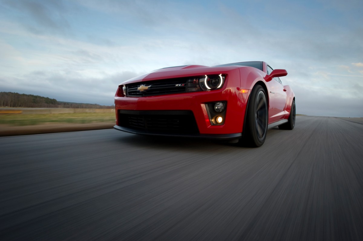 Red 2013 Chevrolet Camaro ZL1 driving down road for photoshoot, same spec as the cheapest one for sale