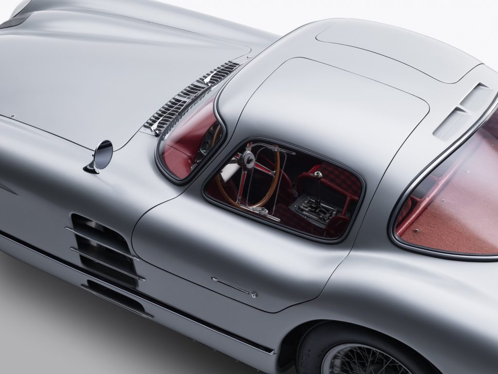 The overhead driver-side view of the tartan-red interior of the silver 1955 Mercedes-Benz 300 SLR Uhlenhaut Coupe