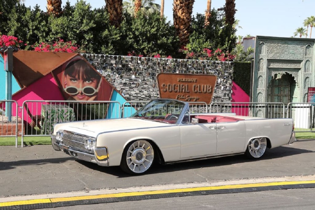 A white 1962 Lincoln Continental shows off its suicide doors at a social club. 