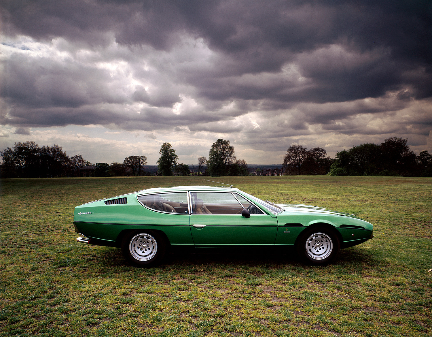 Green 1970 Lamborghini Espada Series II Classic Model sitting in grass field during cloudy day