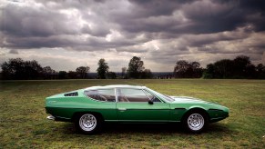 Green 1970 Lamborghini Espada Series II Classic Model sitting in grass field during cloudy day