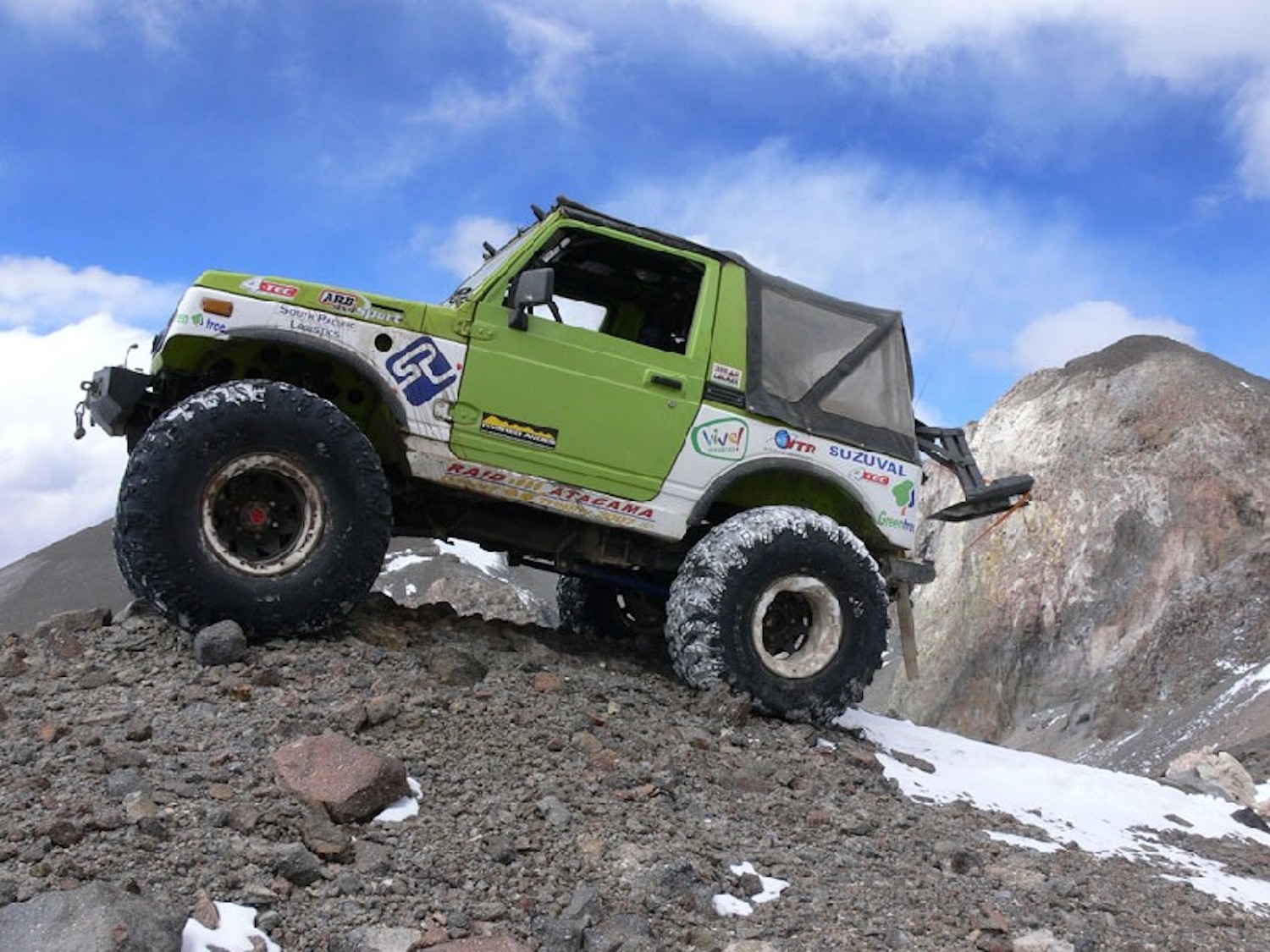 Green 1986 Suzuki Samurai parked on top of a mountain in Chile.