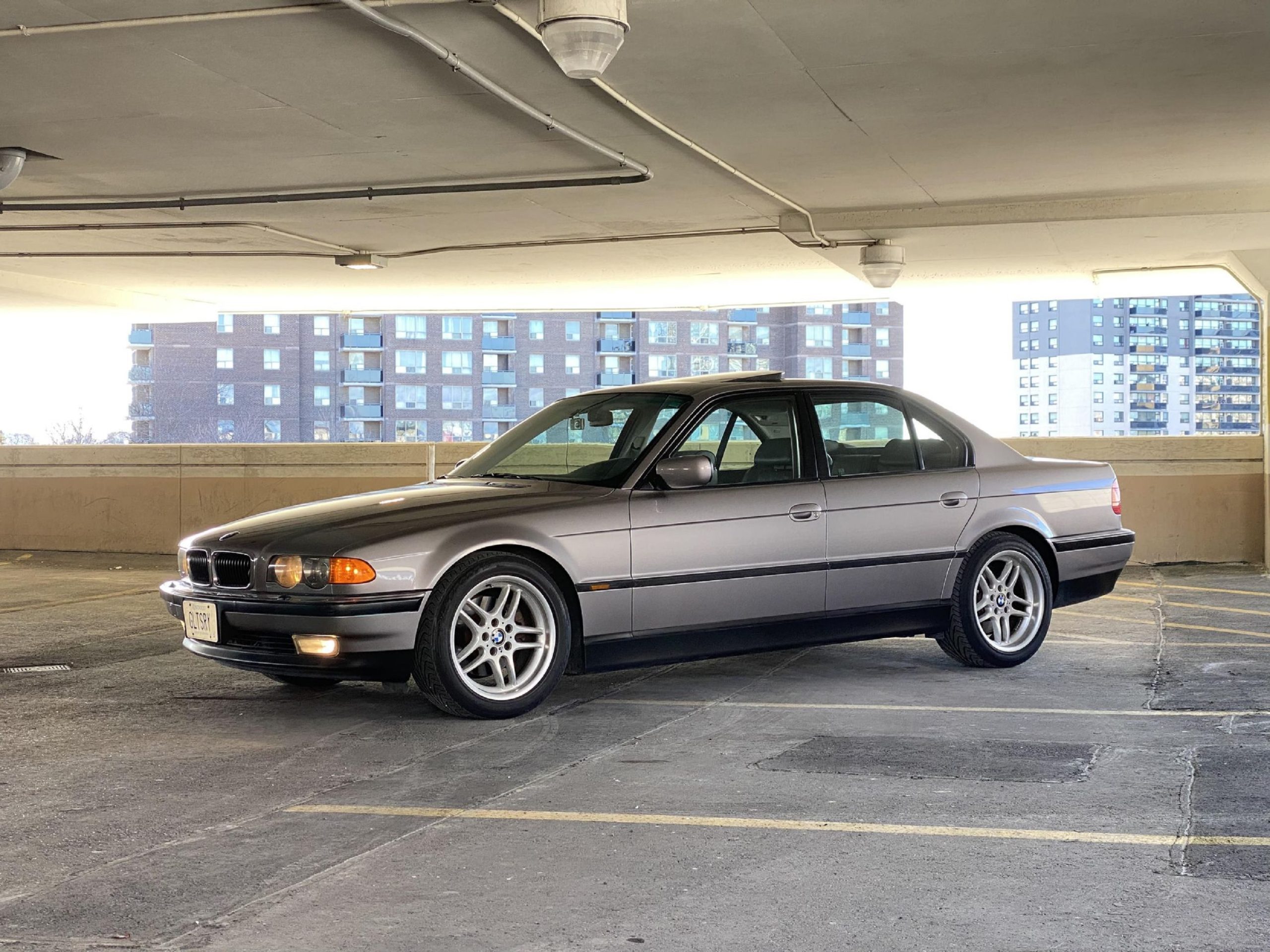 A gray 2000 E38 BMW 740i M Sport in a city parking garage