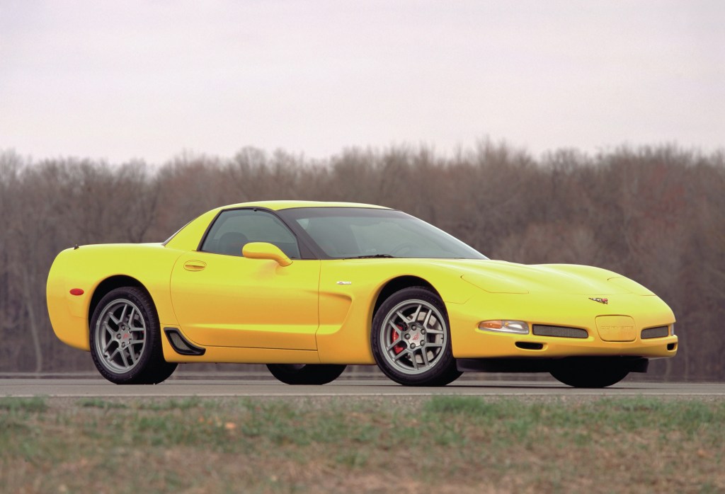 A yellow 2001 C5 Chevrolet Corvette Z06 on a racetrack next to a forest