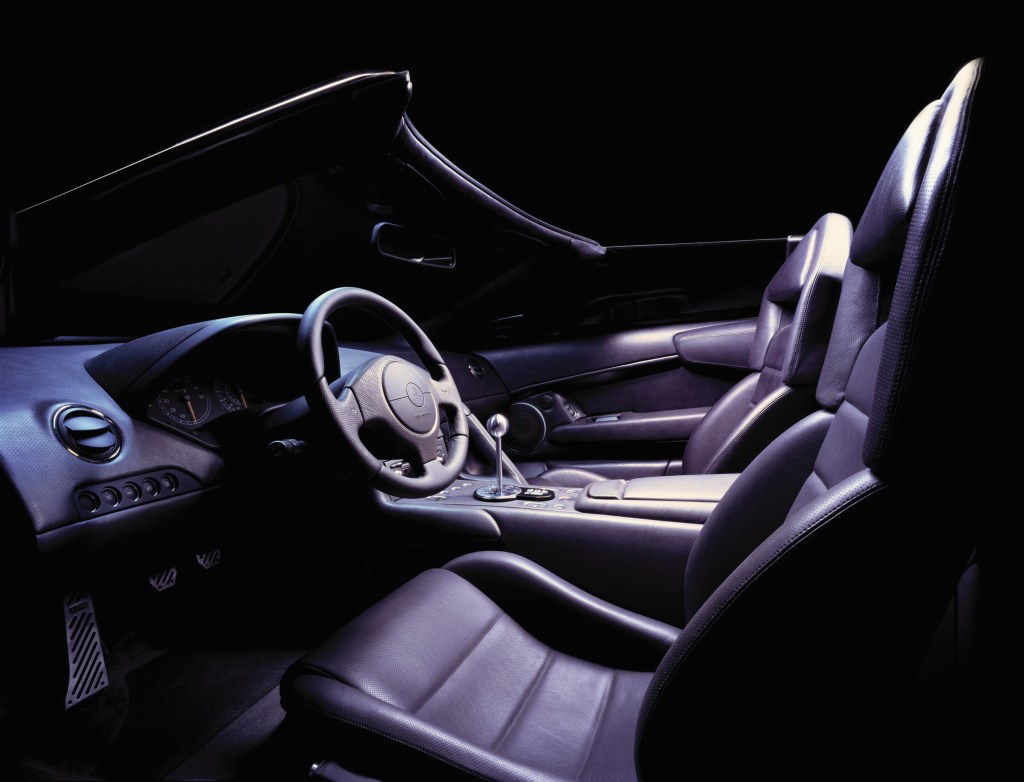 The black leather-and-Alcantara interior of a 2002-2006 Lamborghini Murcielago Roadster with a gated manual