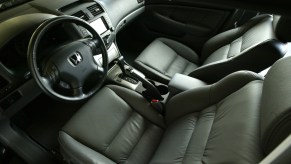 The gray-leather front seats and dashboard of a 2005 7th-gen Honda Accord Hybrid