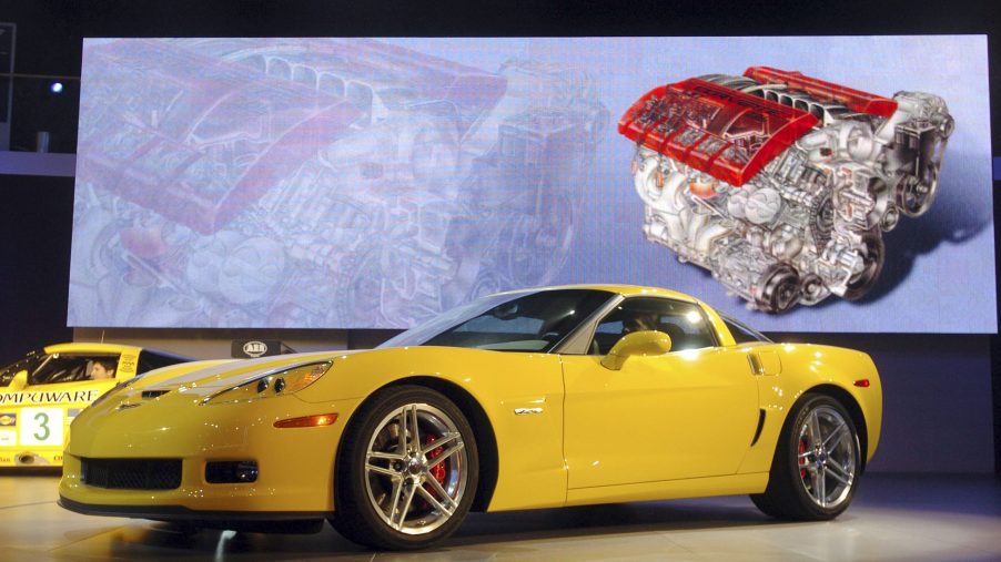 A yellow 2006 C6 Chevrolet Corvette Z06 on stage at the 2005 NAIAS in front of an LS7 V8 diagram