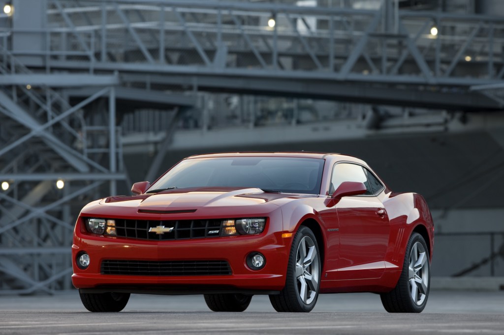 A red 2010 Chevrolet Camaro SS in front of a factory