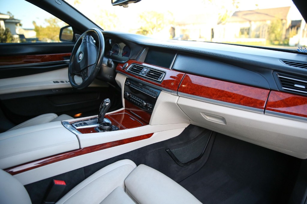 The beige-leather front seats and wood-trimmed black dashboard of a 2014 BMW Alpina B7