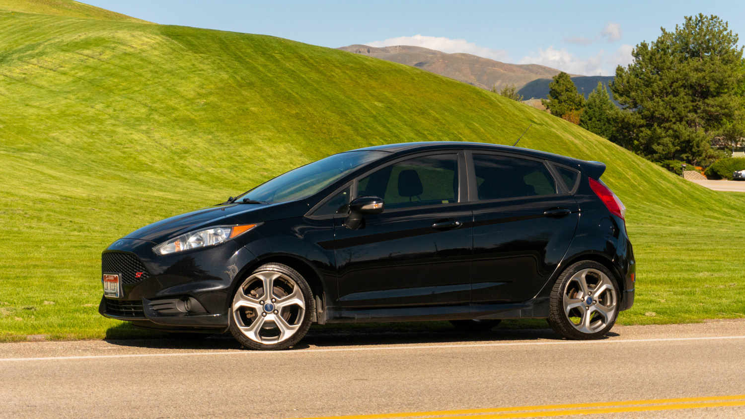 Shadow Black 2016 Ford Fiesta ST parked in front of grassy hill in Boise, Idaho foothills