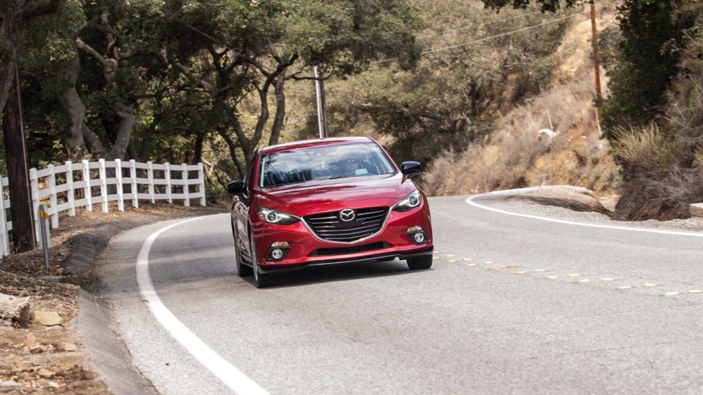a sporty 2016 mazda3 tackles a twisty road and shows off its sportiness in the compact sedan market