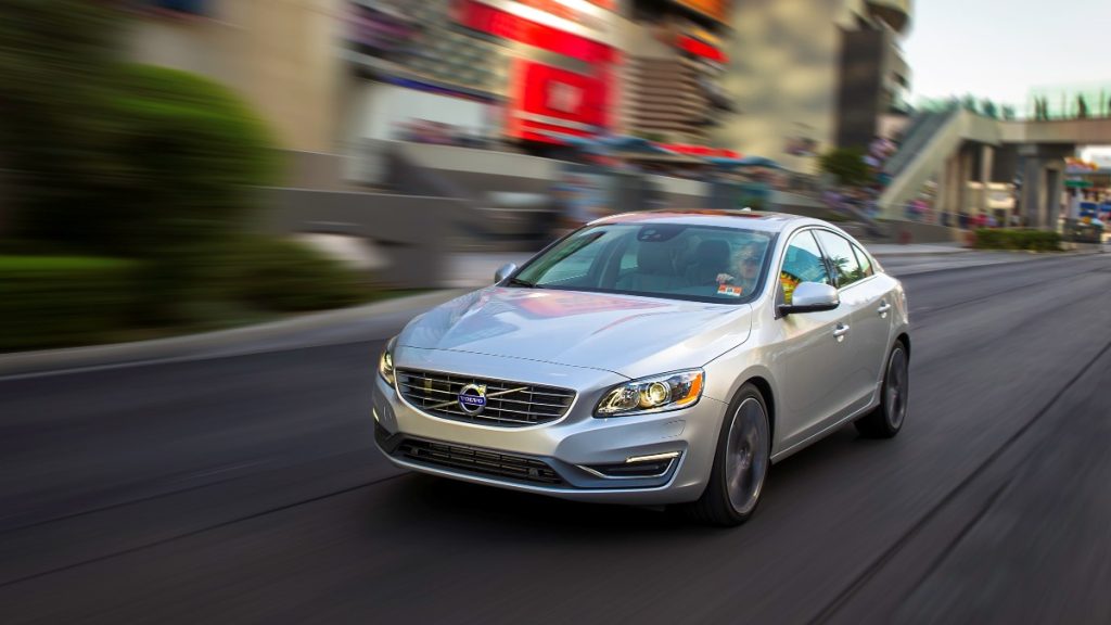 a 2015 Volvo s60 drives through a busy city street, showing its prowess as a compact car