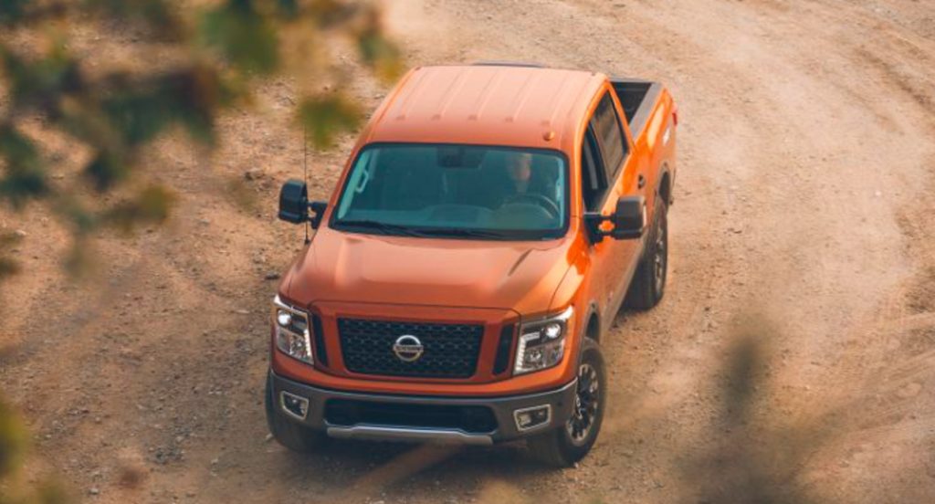 An orange 2019 Nissan Titan Pro 4X full-size pickup truck is off-road. 