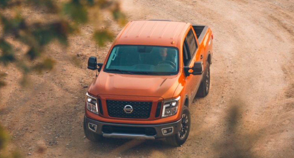 An orange 2019 Nissan Titan Pro 4X full-size pickup truck is off-roading. 