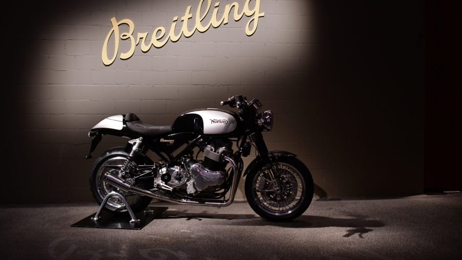 The side view of a black-and-white 2019 Norton Commando 961 in front of a Breitling wall sign