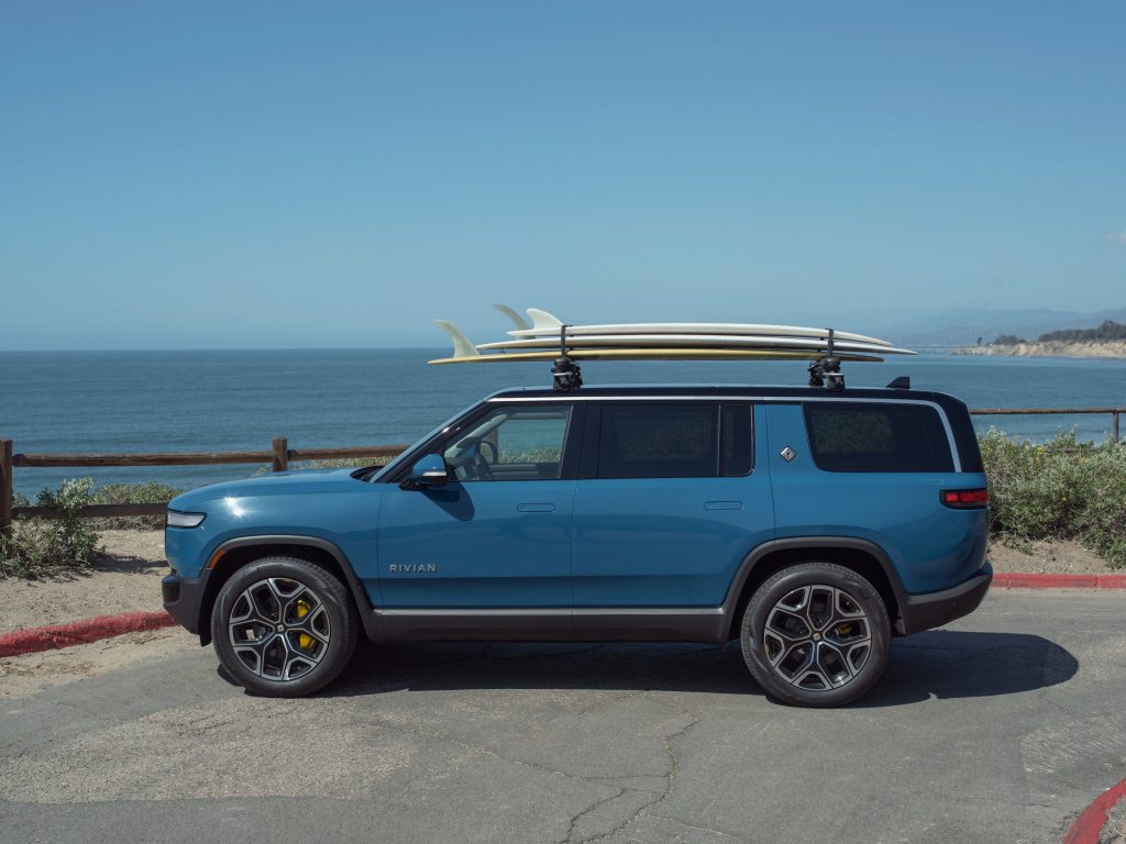 A blue Rivian R1S with the surfboard holoder