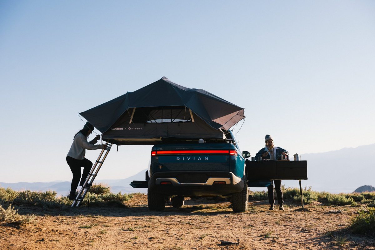 A Rivian R1T with a tent and stove attached