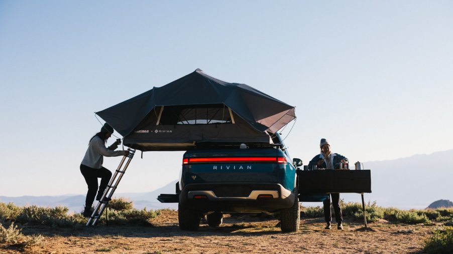 A Rivian R1T with a tent and stove attached