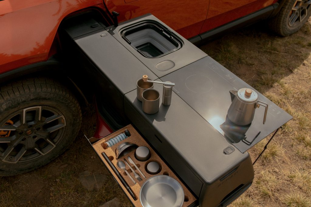 a red Rivian truck with the camp stove package