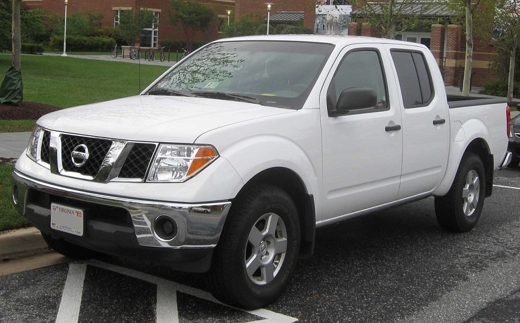 A white Nissan Frontier sits in a parking lot as a mid-size truck.
