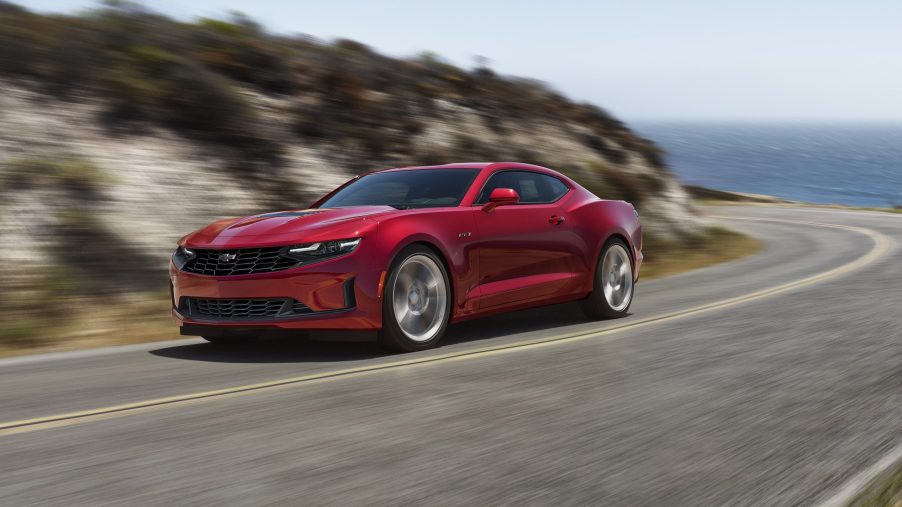 A red 2022 Chevrolet Camaro LT1 driving around an ocean road
