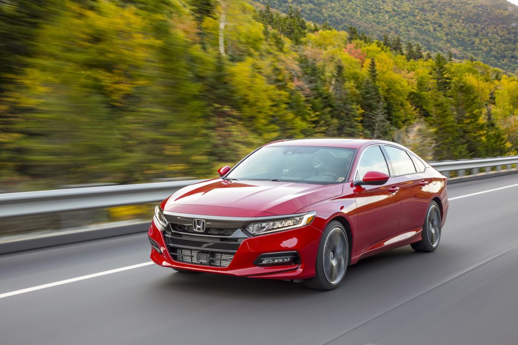 A red 2022 Honda Accord Sport 2.0T on a forest mountain road