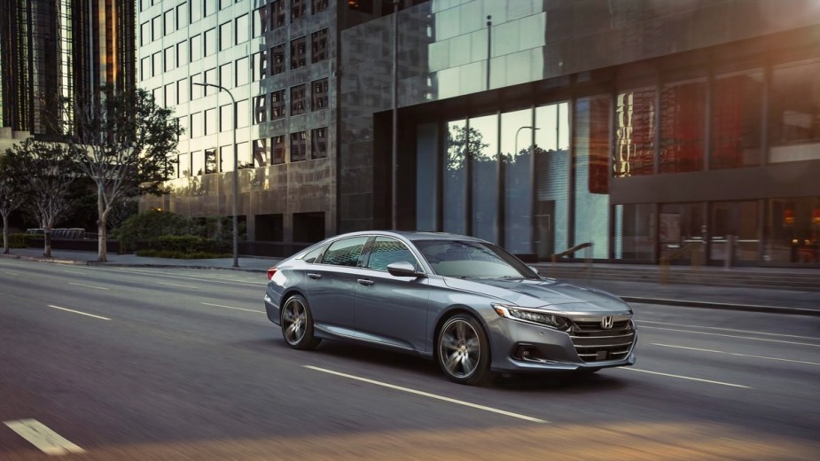 a silver honda accord drives down the road, a comfortable and modern sedan that offers you a ton of different driver assistance technology