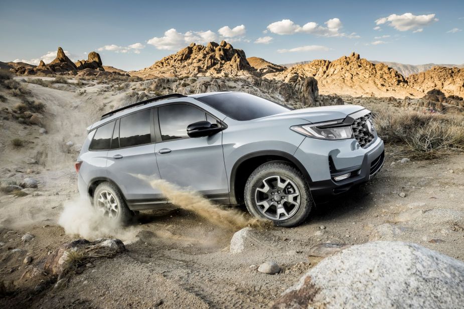 2022 Honda Passport Trailsport compact adventure SUV climbing up a dusty rock trail in a desert mountain