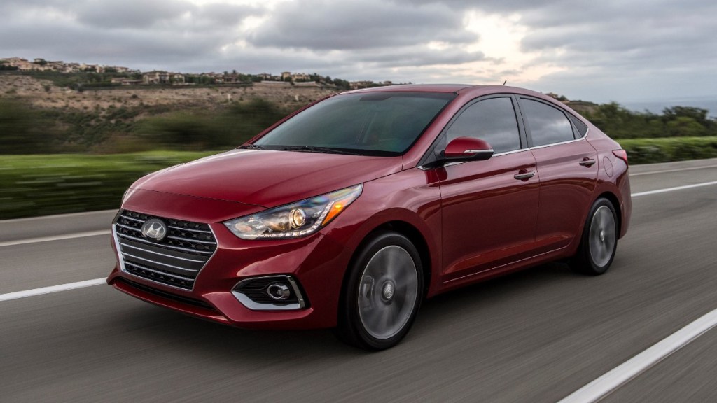 a red 2022 hyundai accent limited drives along a road, showing off its sleek body lines