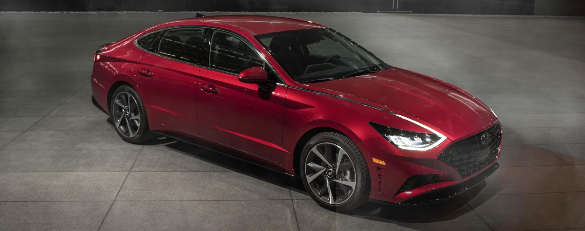 An overhead view of a red 2022 Hyundai Sonata parked on a concrete lot in front of a building