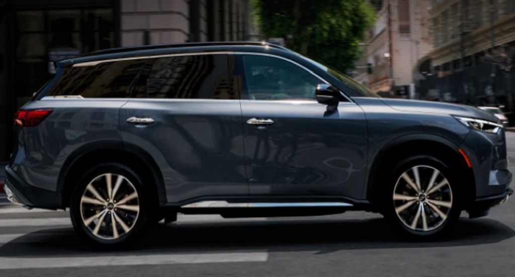 A gray 2022 Infiniti QX60 is driving on the road. 