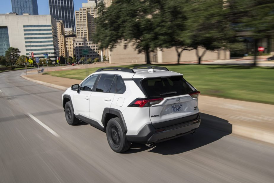 Rear view of 2022 Toyota RAV4 Off Road in white driving on a road.