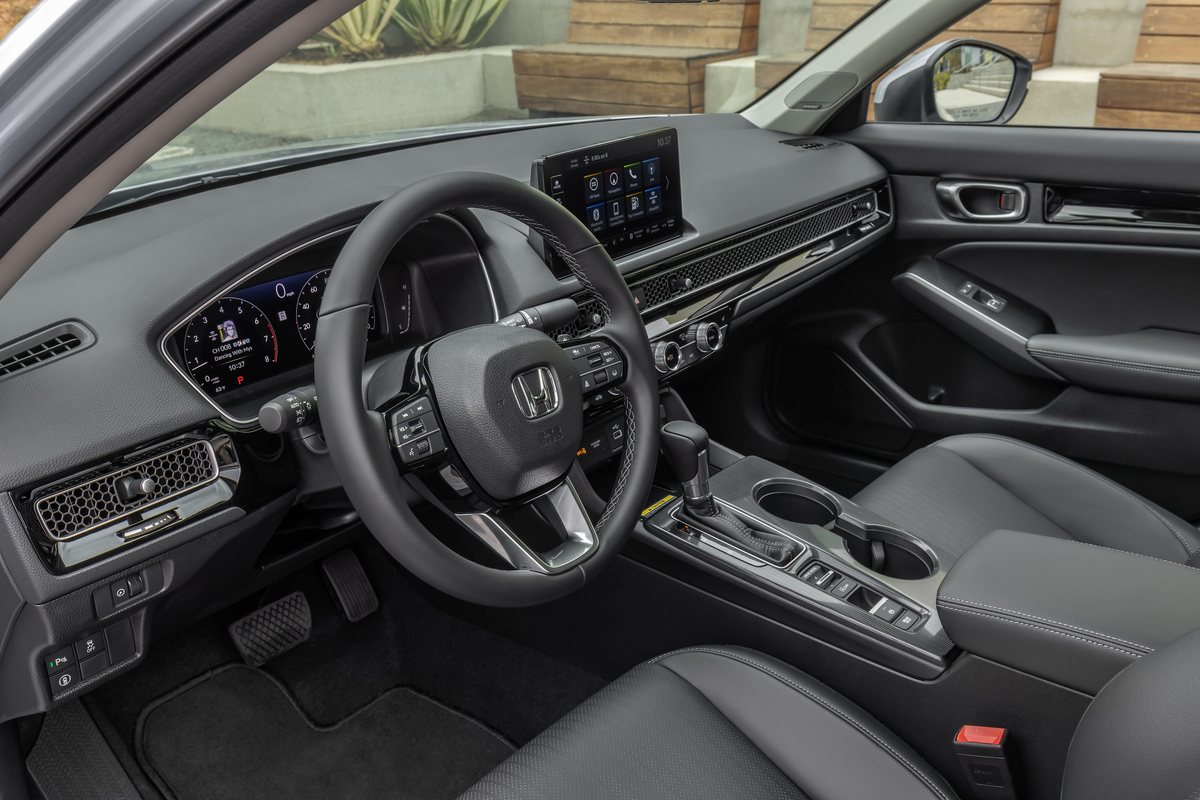 Interior of the 2022 Honda Civic sedan in black fabric.  This sedan is great for commuting to work.