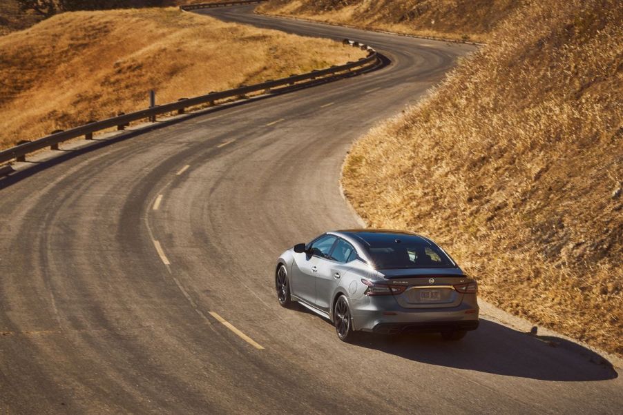 Silver 2022 Nissan Maxima sedan driving away along a winding road. Is the Maxima being discontinued?
