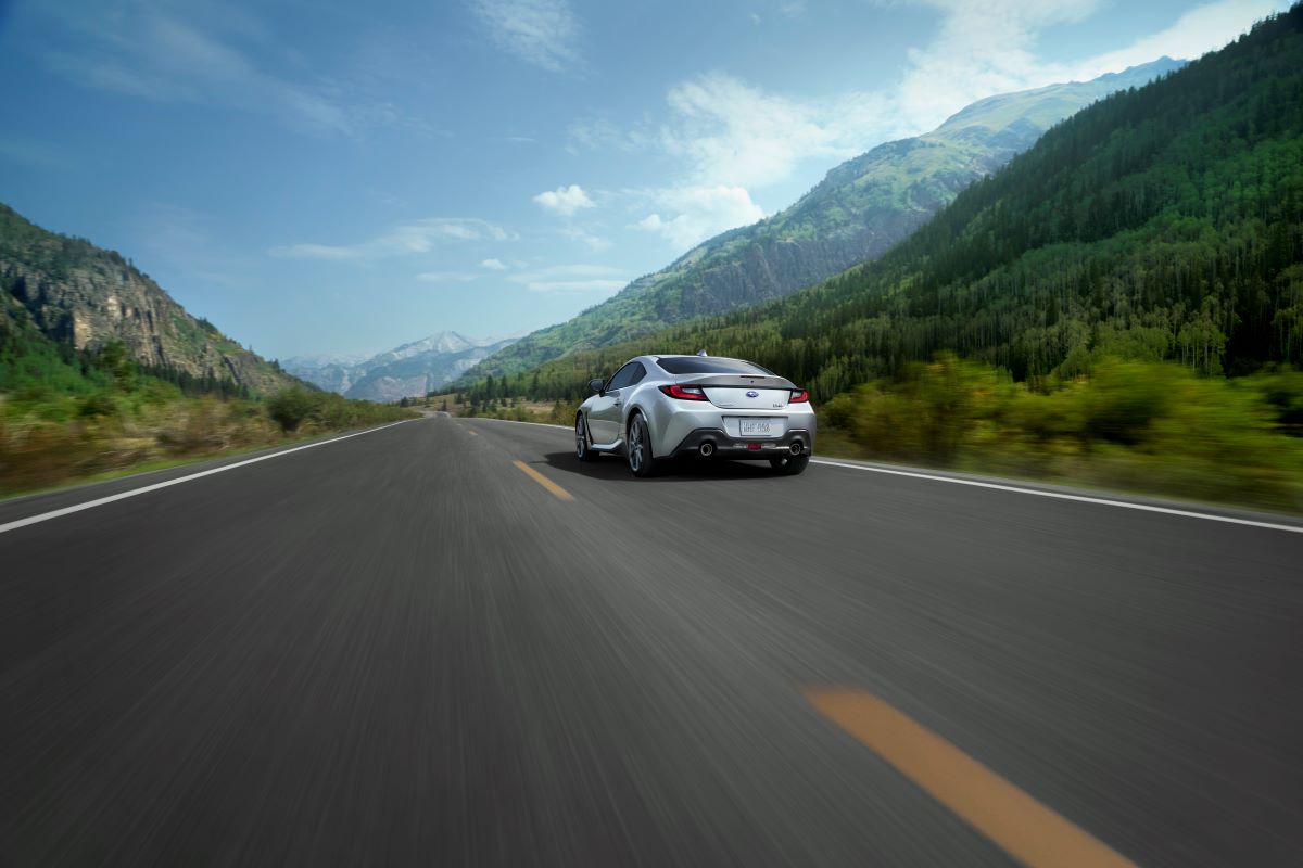 Back of a silver 2022 Subaru BRZ, a Top Safety Pick Plus, pulling away on a road with mountains on both sides