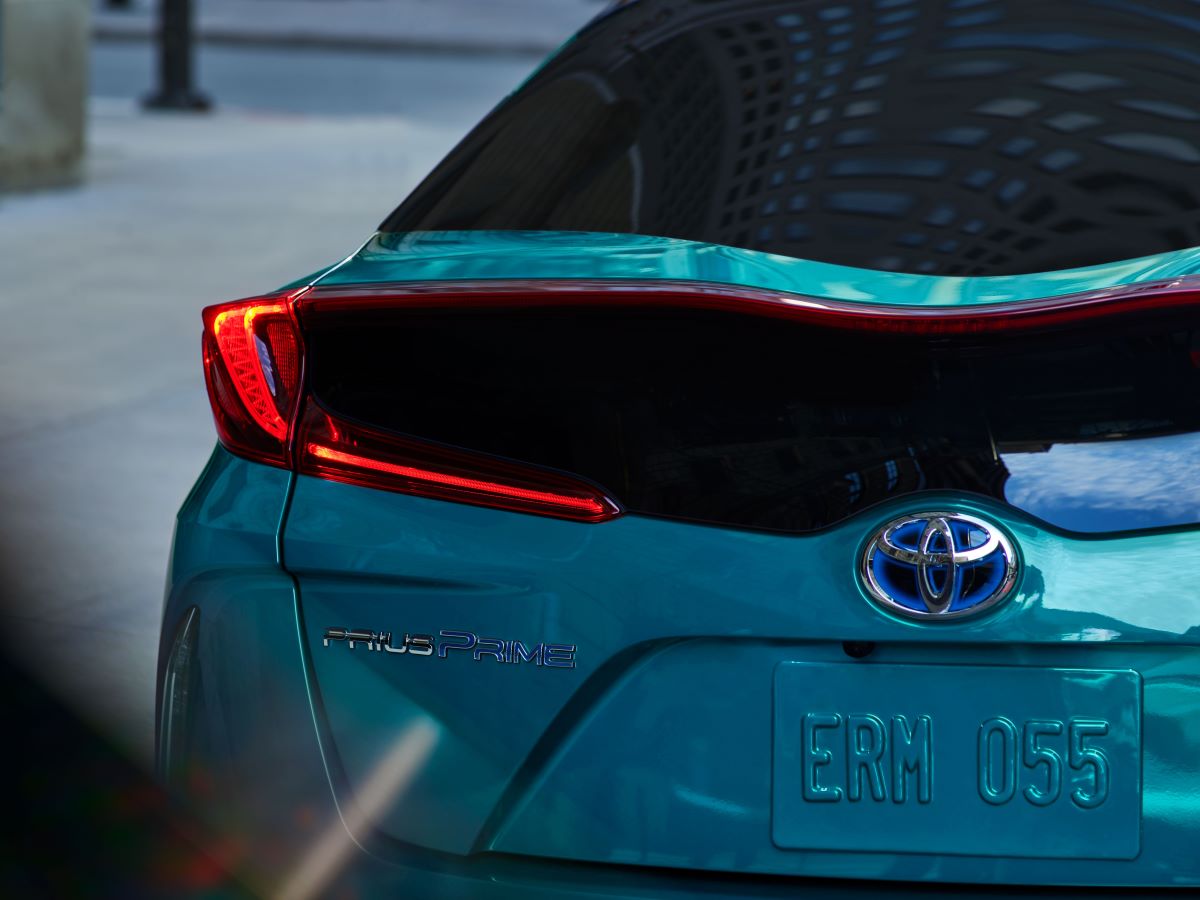 Close up shot of the back of a 2022 Toyota Prius Prime in teal. The Toyota logo and PRIME badging are shown. The Prius Prime is one of the best plug-in hybrid cars under $35,000.