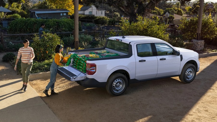 A white 2022 Ford Maverick compact pickup truck has gardening soil loaded into its bed.