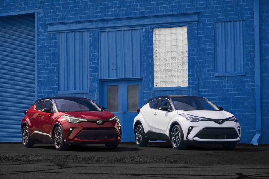 Two Toyota C-HR crossovers in front of a blue building