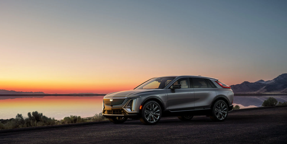 A gray 2023 Cadillac Lyriq luxury electric SUV model parked near a beach during sunset