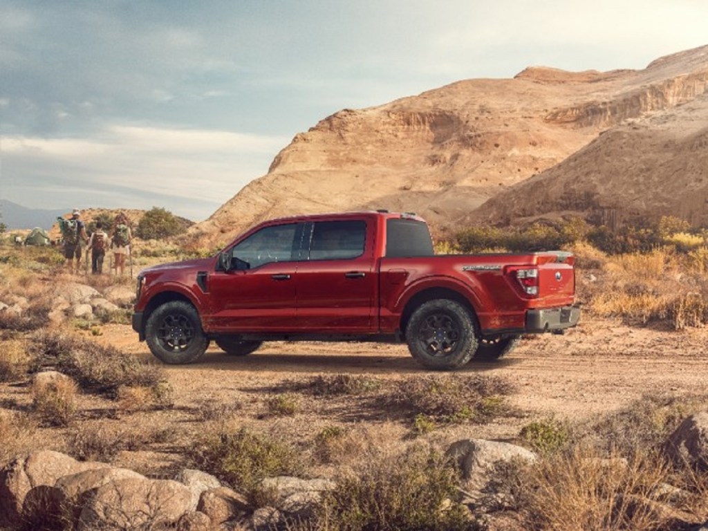 A red 2023 Ford F-150 in front of rocks.