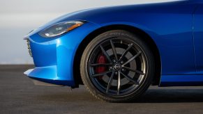 A side view of a blue 2023 Nissan Z Performance's front Bridgestone Potenza tire and black wheel