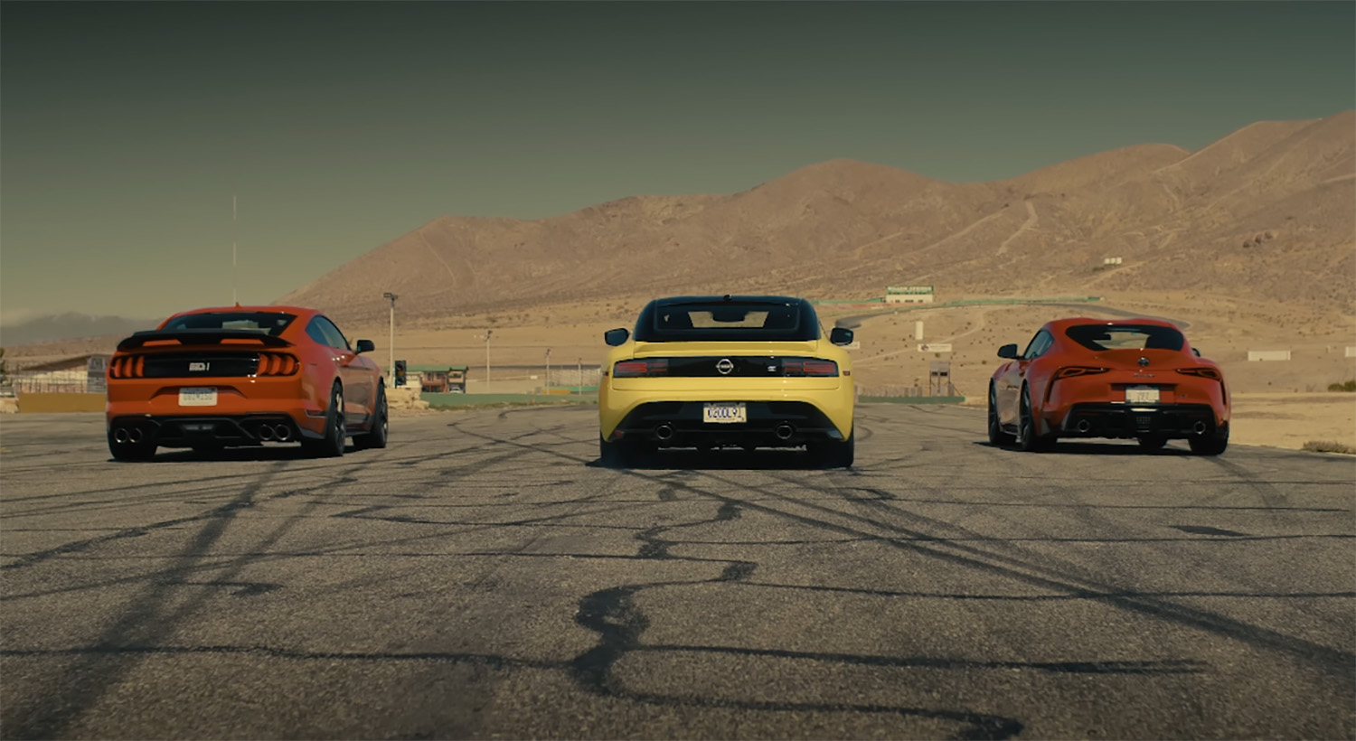 Heads up drag race between yellow 2023 Nissan Z automatic against red 2022 Ford Mustang Mach 1 and red 2022 Toyota GR Supra 3.0