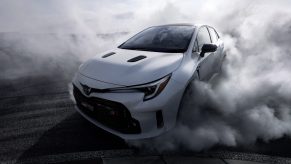The front 3/4 view of a white 2023 Toyota GR Corolla Circuit Edition doing a burnout on a track