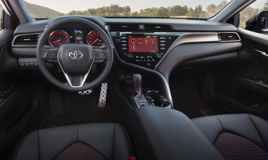 Interior of the 2023 Toyota Camry TRD sports sedan. The upholstery is black with red piping.