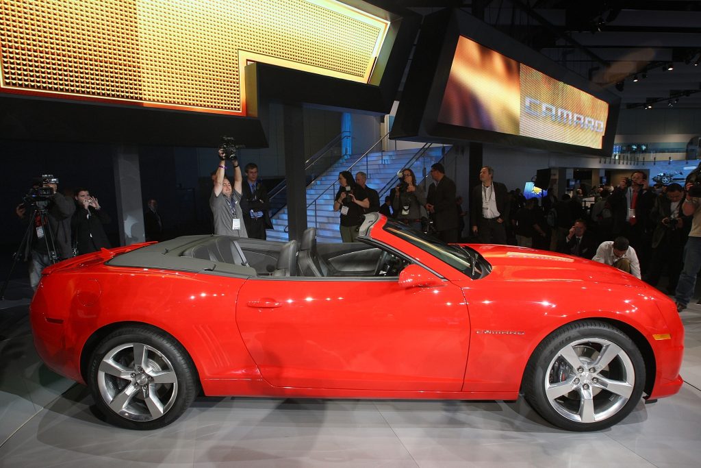 The side view of a red 2011 Chevrolet Camaro Convertible at the 2010 LA Auto Show