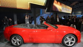 The side view of a red 2011 Chevrolet Camaro Convertible at the 2010 LA Auto Show