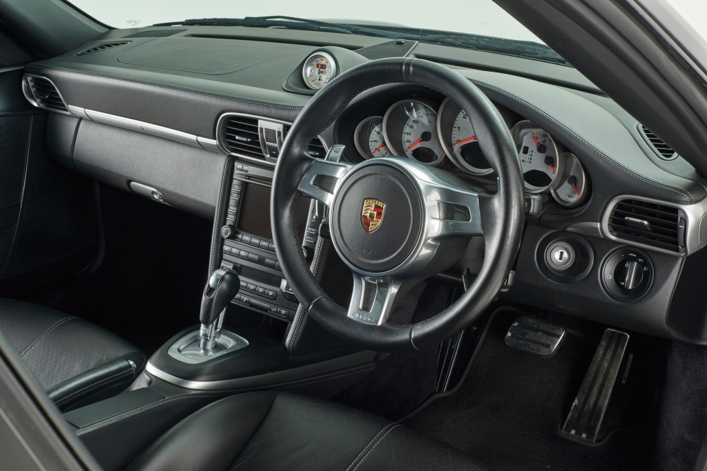 The black-leather front seats and dashboard of a UK-market 997.2 Porsche 911 Turbo with the Sport Chrono Package
