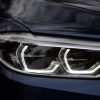 A dark-blue 2018 BMW M550i's full-LED adaptive headlights